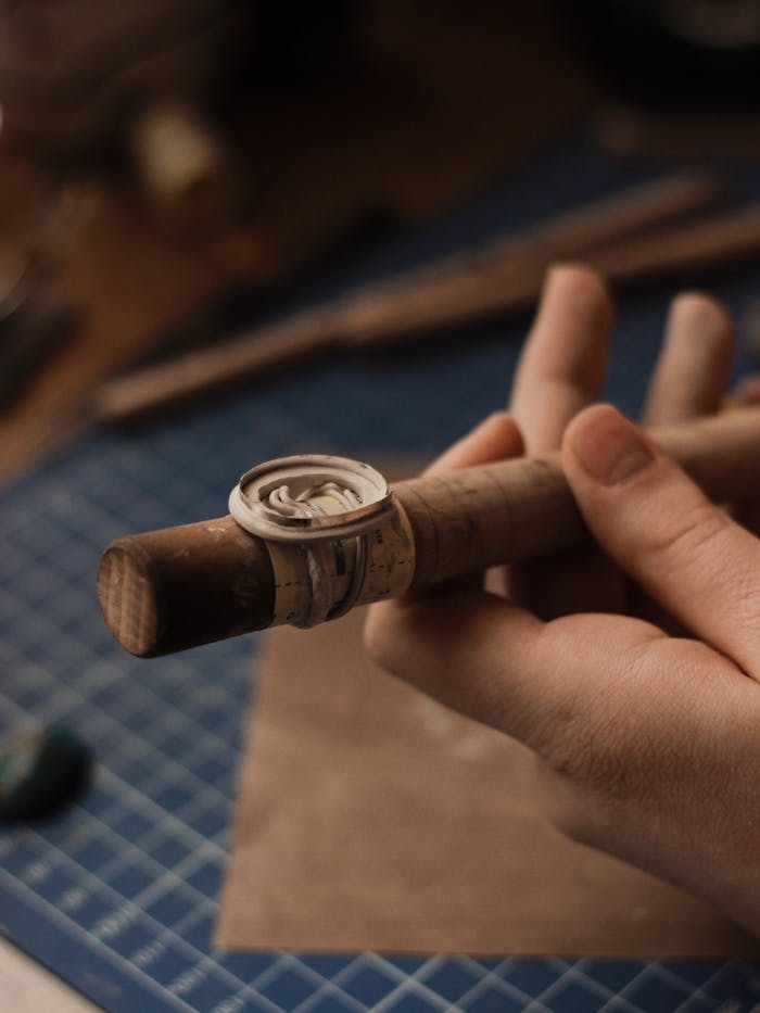 Close-up of a jeweler crafting a silver ring using traditional tools in a workshop.